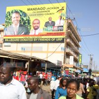 Members of the public walk past a massive campaign billboard