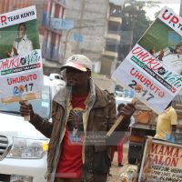 A Jubilee backer lifts placards during a campaign rally