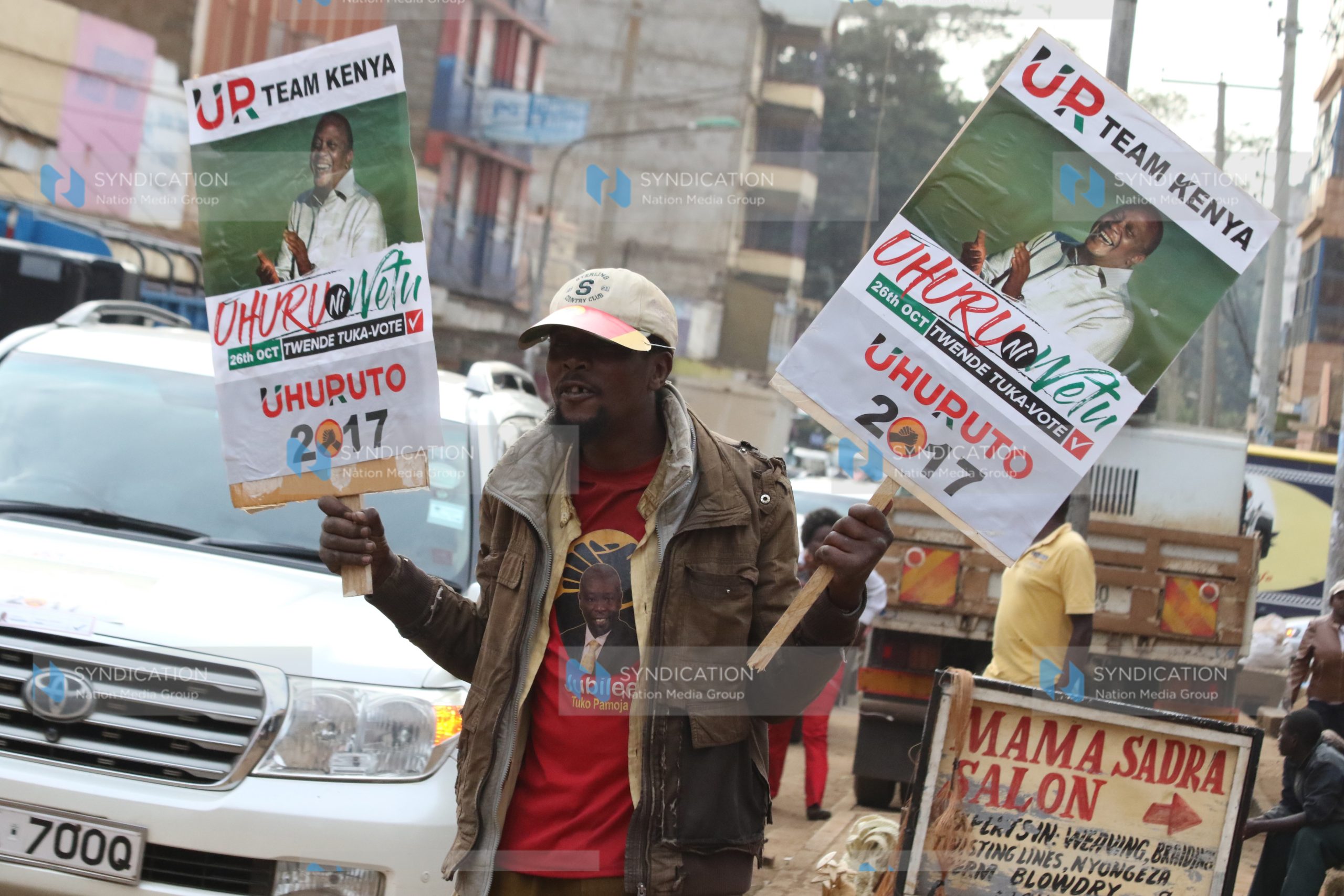 A Jubilee backer lifts placards during a campaign rally