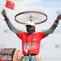 A Jubilee supporter lifts party flags during a campaign rally