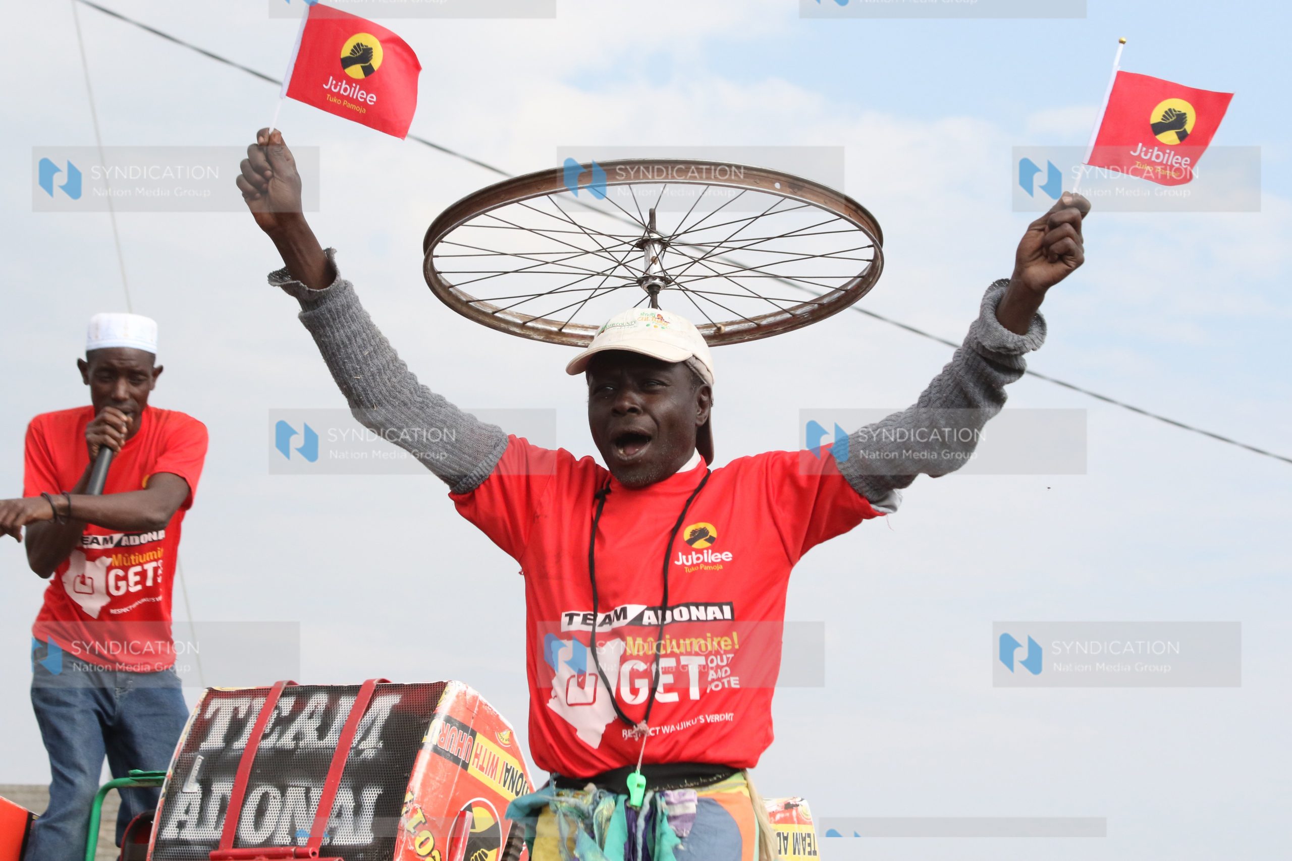 A Jubilee supporter lifts party flags during a campaign rally