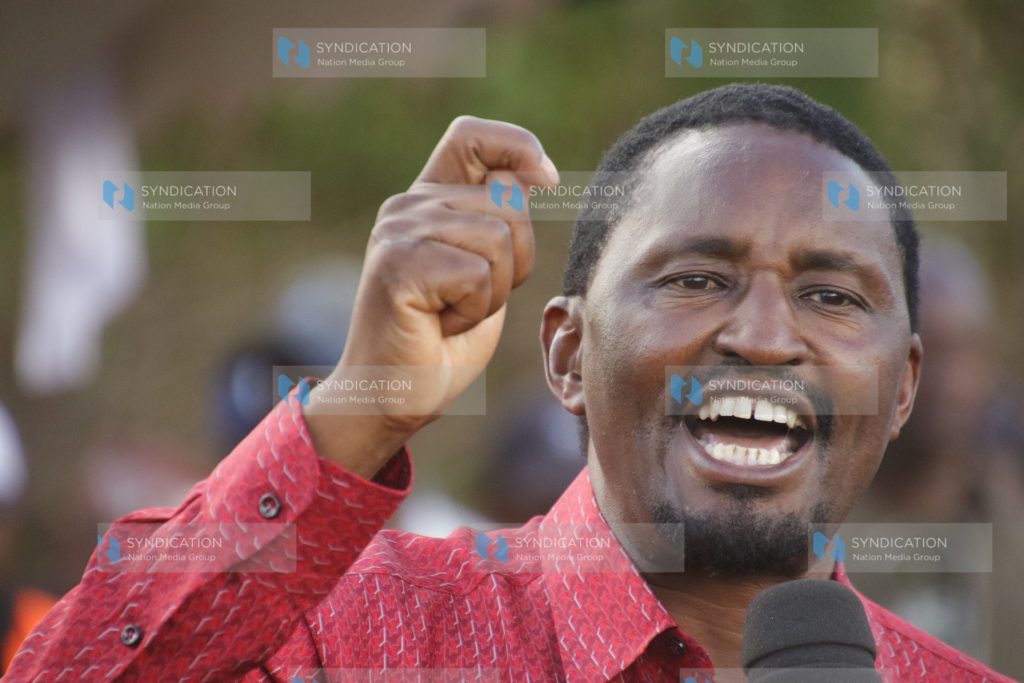 Laikipia East MP Mwangi Kiunjuri stands atop a public address speaker to address residents at Mahiga