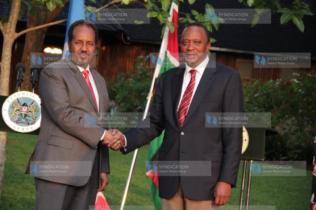 President Uhuru Kenyatta, right, shake hands with President Hassan Sheikh Mohamud