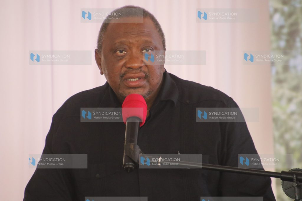 Former President Uhuru Kenyatta speaks to mourners during the burial of Kanja Waruru