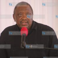 Former President Uhuru Kenyatta speaks to mourners during the burial of Kanja Waruru