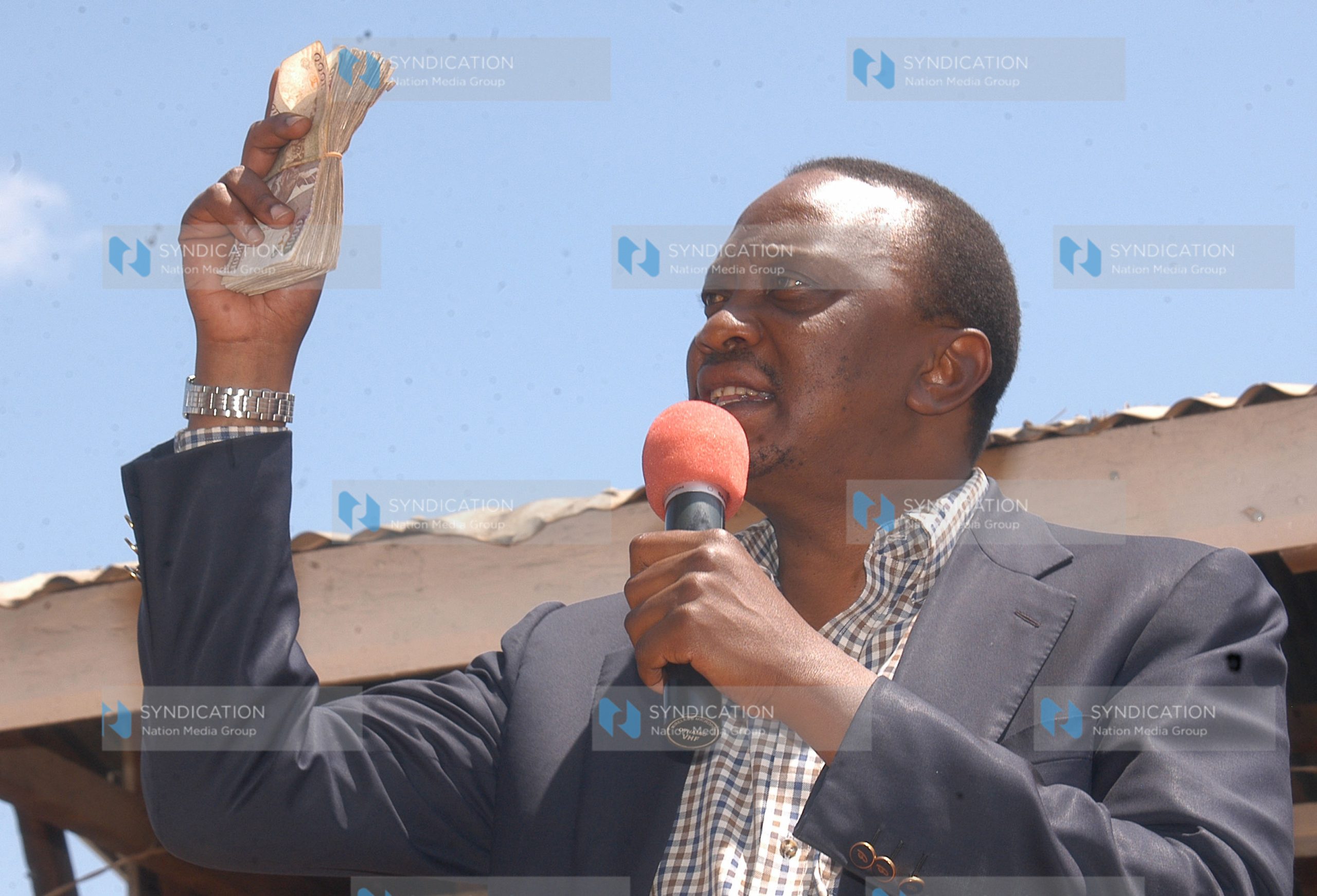 Deputy Prime Minister Uhuru Kenyatta displays notes during a fund drive for Nanyuki PCEA parish