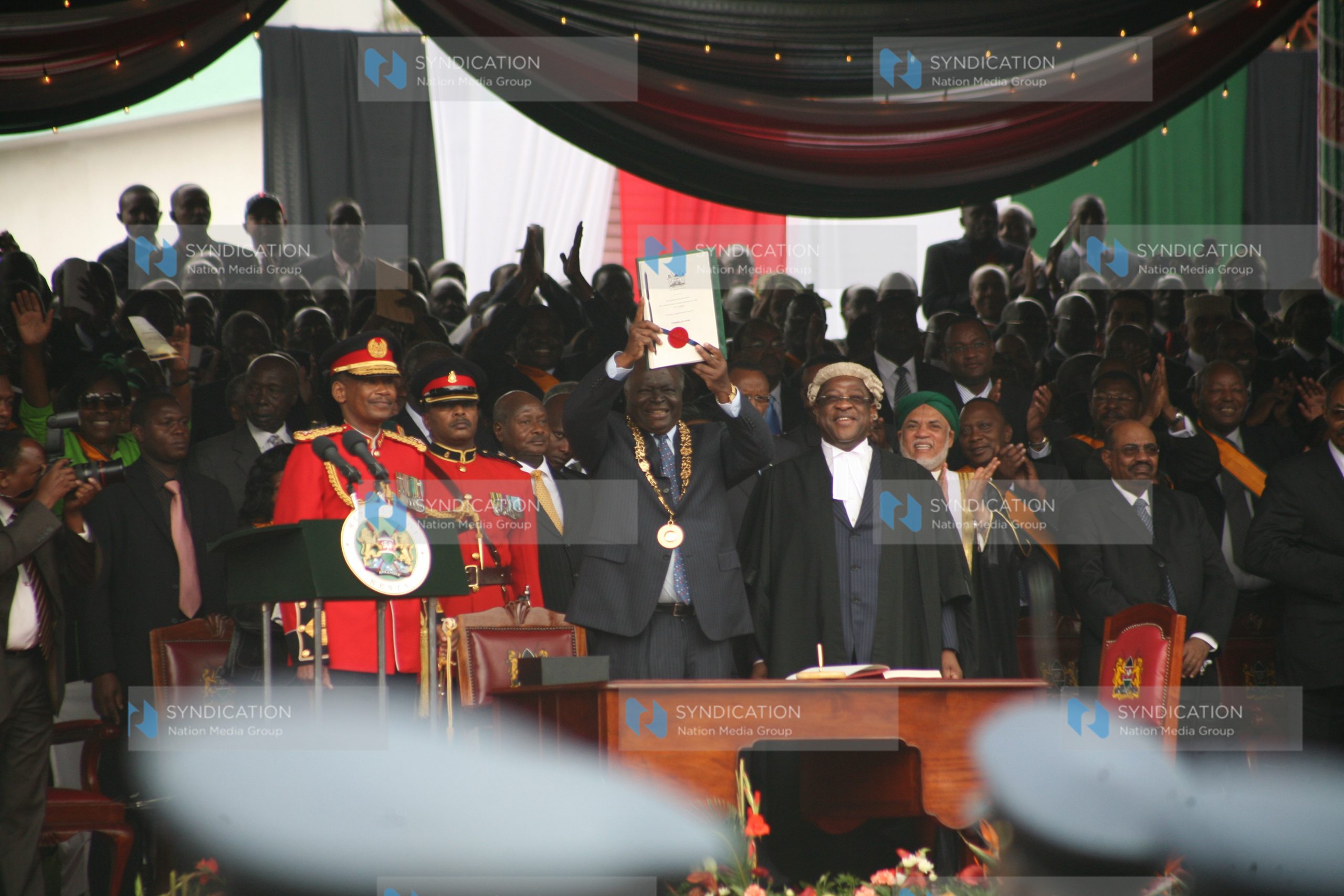 President Mwai Kibaki displays the official new constitution document