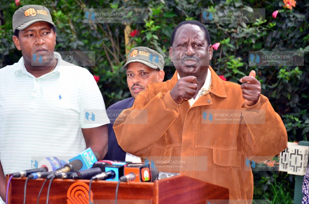 Raila Odinga (right) gestures during a media briefing