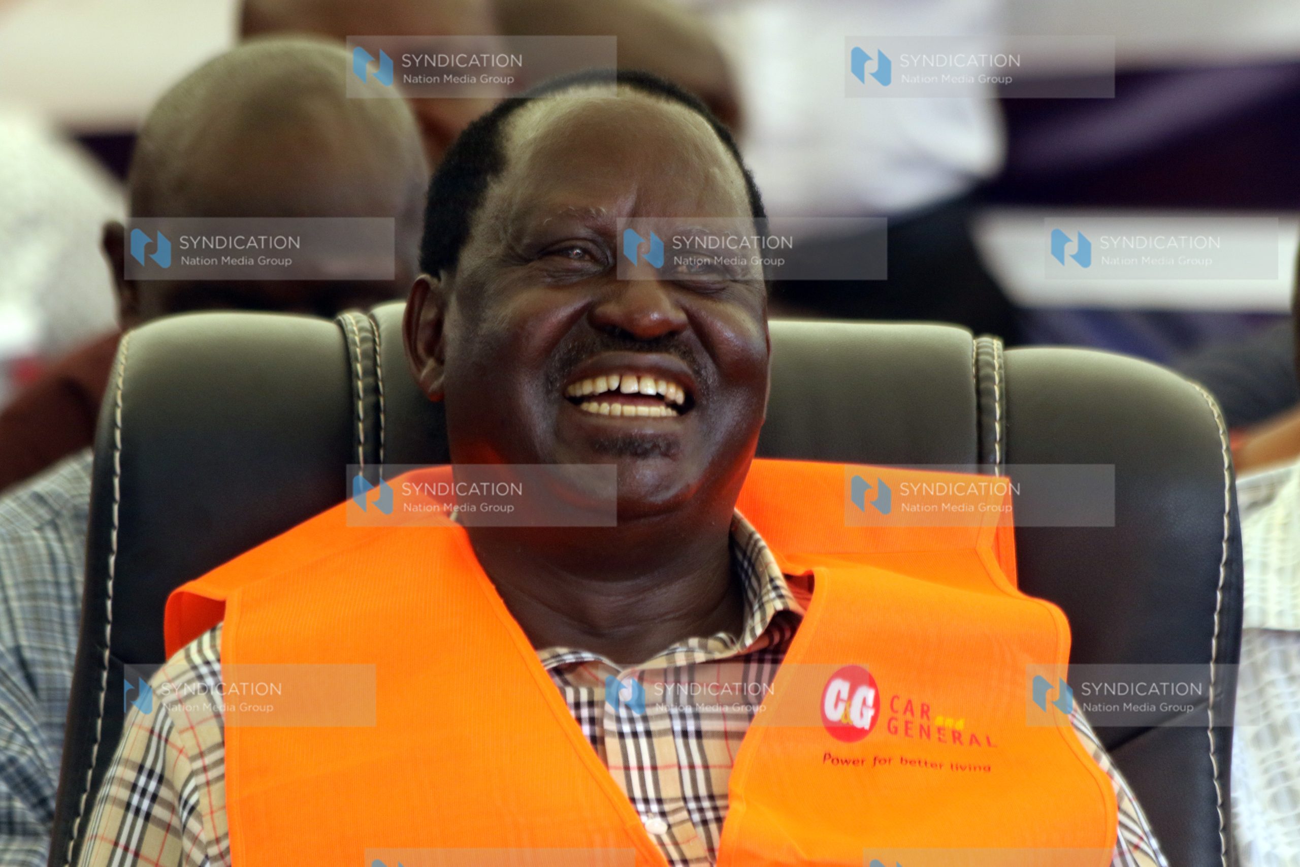 Raila Odinga laughs as he follows proceedings during a meeting with bodaboda riders
