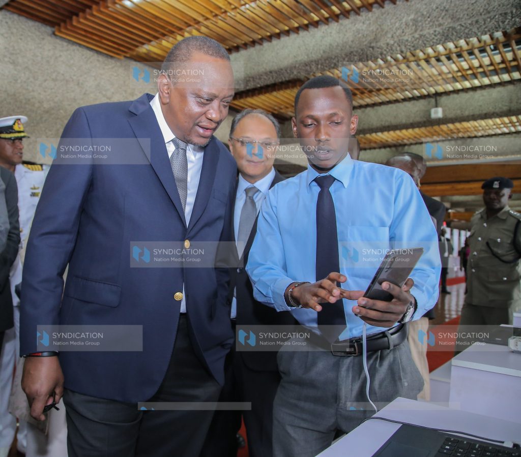 Naboth Tieng a student from Juja Senior School explain to President Uhuru Kenyatta and Ps Dr. Kevit Desai