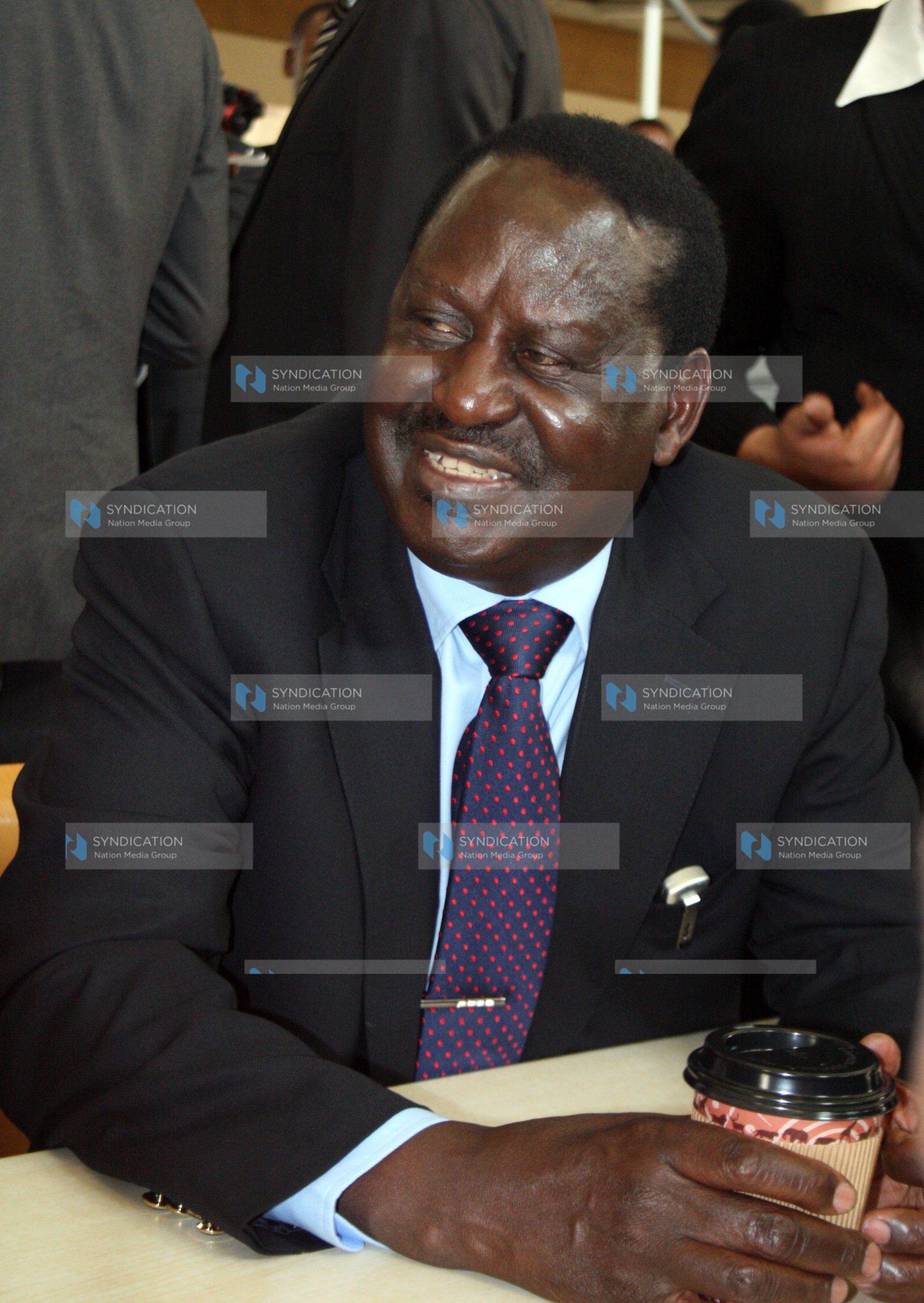 Former Prime Minister Raila Odinga enjoys a cup of coffee and chats with students