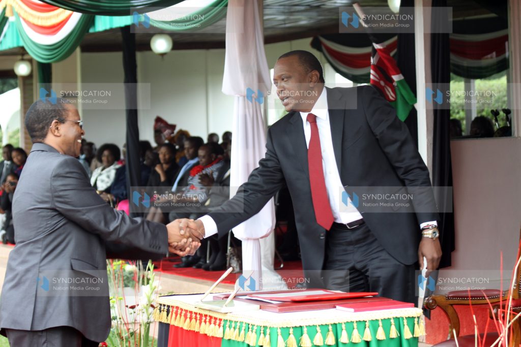Karanja Kibicho with President Uhuru Kenyatta during the swearing-of Principal Secretaries