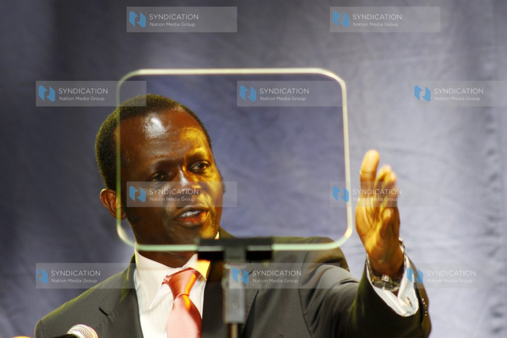 Raphael Tuju reads from the auto-Q during the launching of Party of Action at Kenyatta International Conference