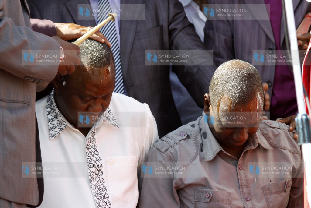 Deputy Prime Minster Uhuru Kenyatta with William Ruto are showered with oil during prayers