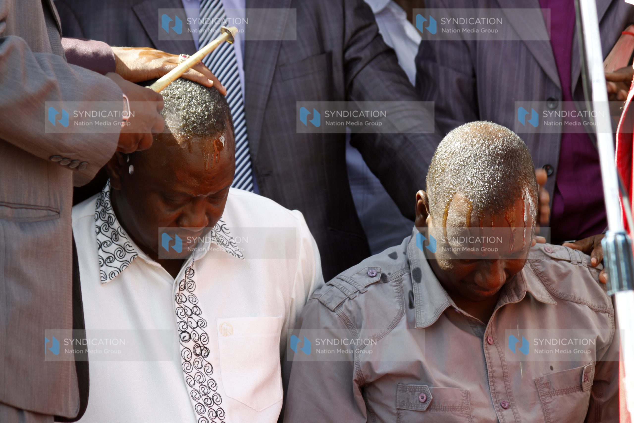 Deputy Prime Minster Uhuru Kenyatta with William Ruto are showered with oil during prayers