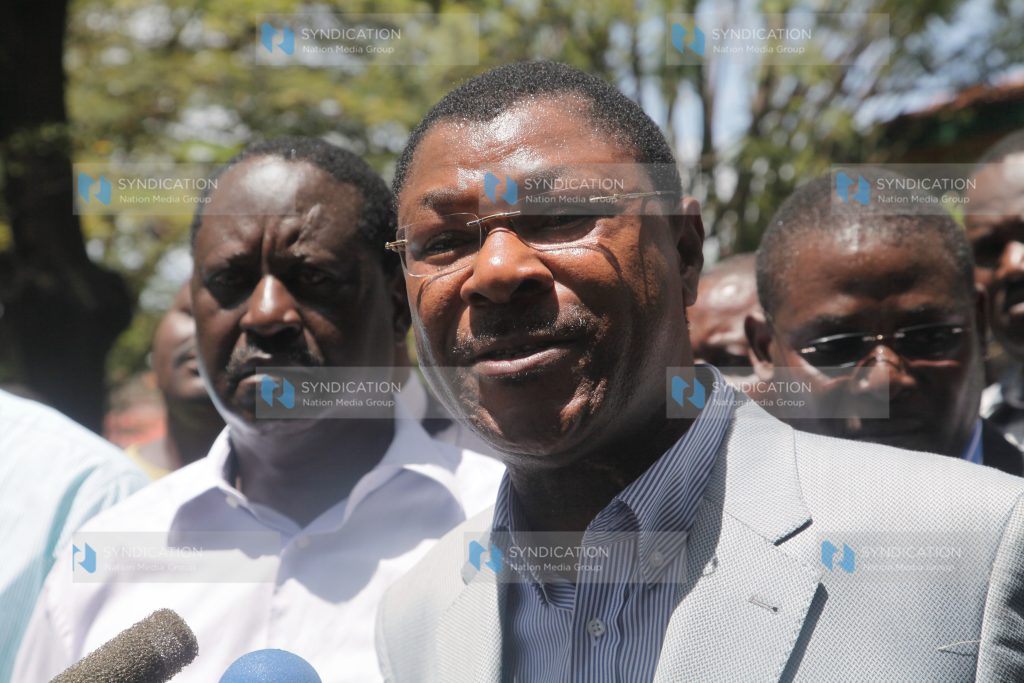 Senator Moses Wetangula addresses the media as Prime Minister Raila Odinga looks on