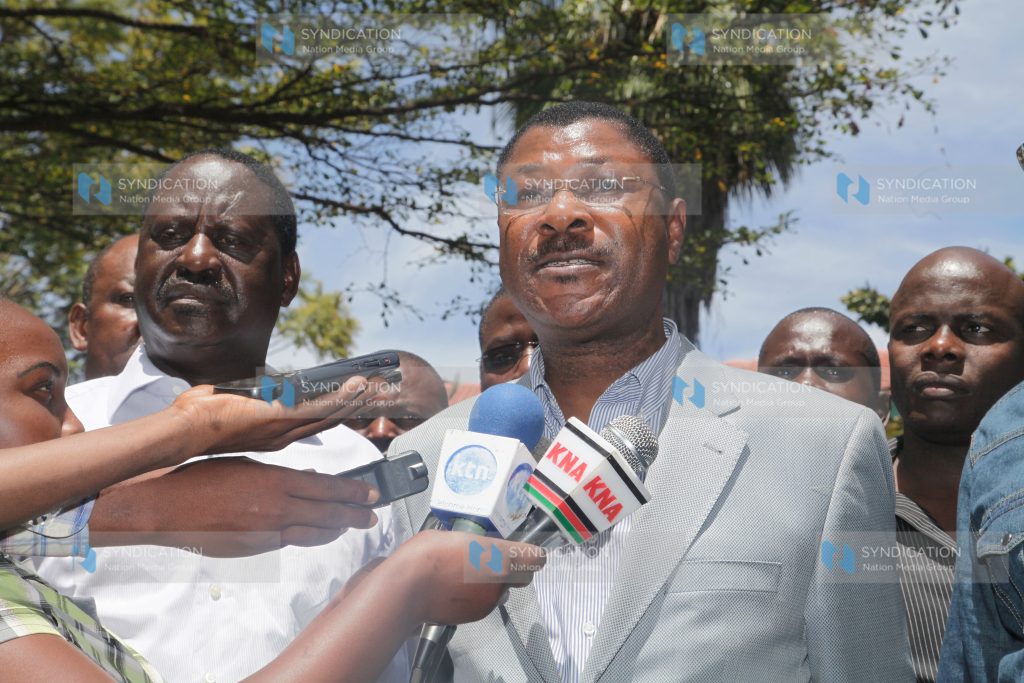 Senator Moses Wetangula addresses the media, flanked by Prime Minister Raila Odinga and Paul Otuoma