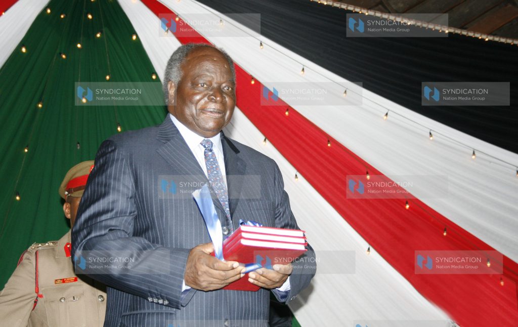 President Mwai Kibaki holds a copy of the published draft constitution