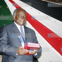 President Mwai Kibaki holds a copy of the published draft constitution