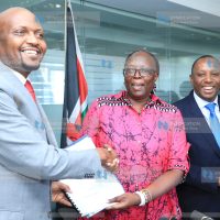 Trade Cabinet Secretary Moses Kuria is handed over some documents by the outgoing Trade CS Betty Maina
