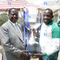Gor Mahia captain Jerim Onyango hands over the SportPesa Premier League trophy to CORD leader and club patron Raila Odinga