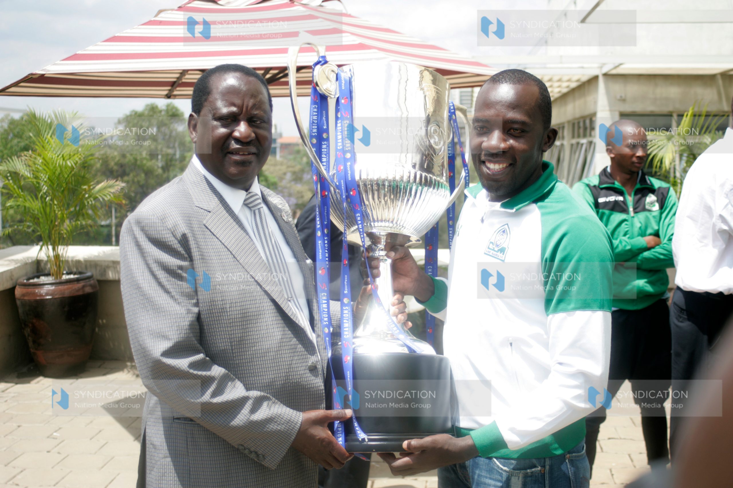 Gor Mahia captain Jerim Onyango hands over the SportPesa Premier League trophy to CORD leader and club patron Raila Odinga