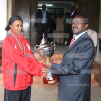 Vice President Kalonzo Musyoka receives a trophy from Jane Wacu