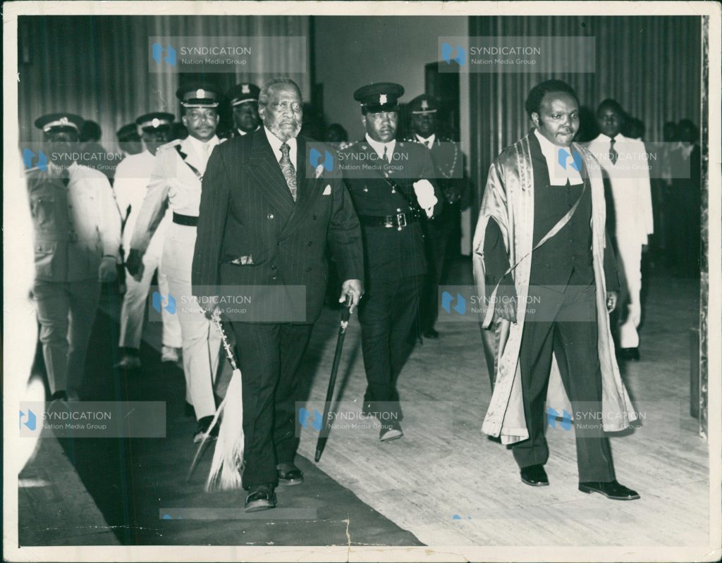 Mzee Jomo Kenyatta (left) is escorted into the Parliament Buildings