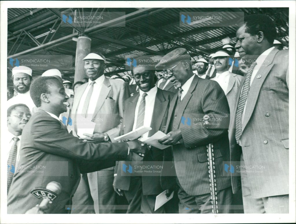 Mr. Imanyara (left), presents to the party’s national chairman Jaramogi Oginga Odinga a briefing to be read to party members during a function at City Stadium