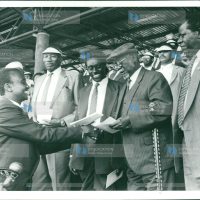 Mr. Imanyara (left), presents to the party’s national chairman Jaramogi Oginga Odinga a briefing to be read to party members during a function at City Stadium
