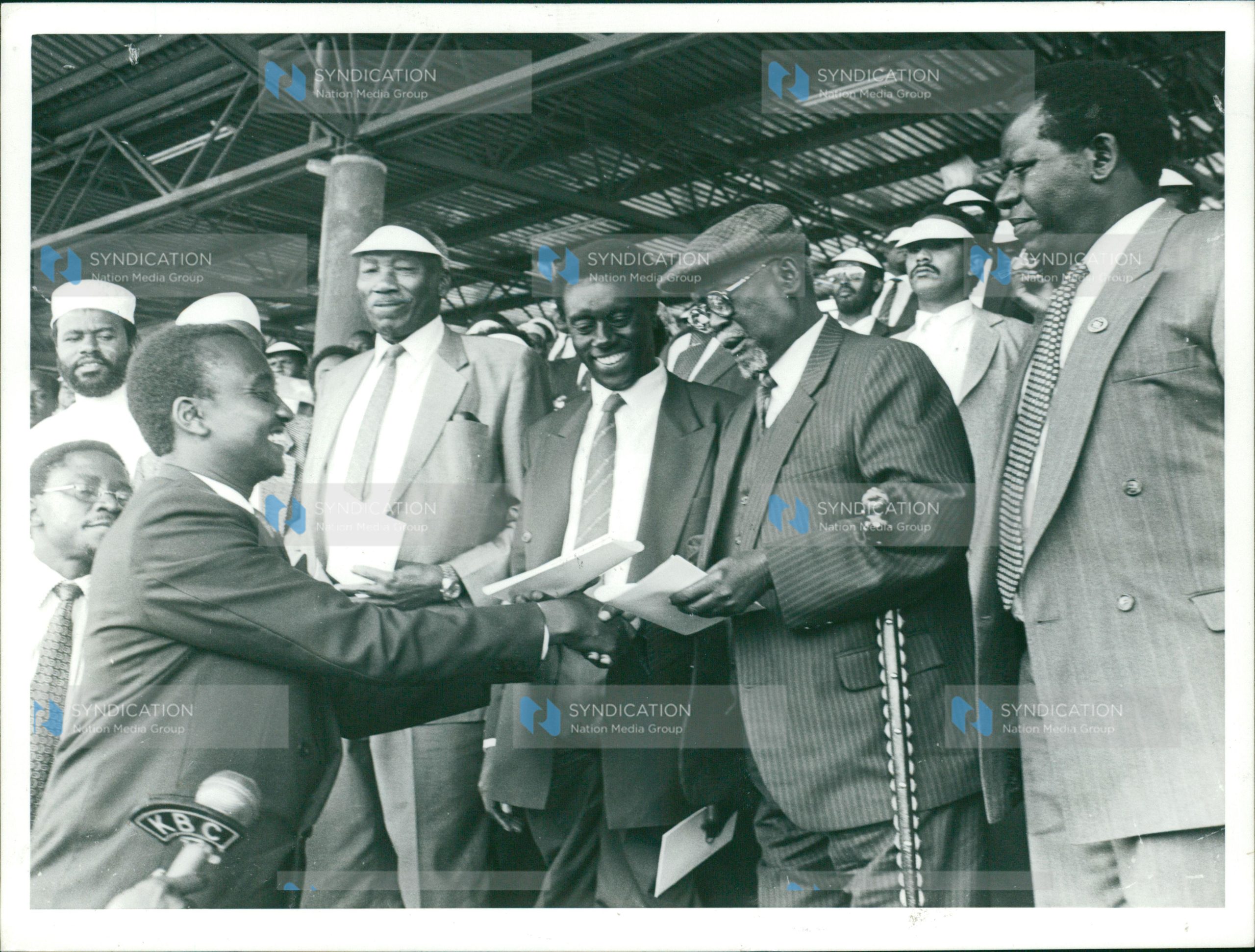 Mr. Imanyara (left), presents to the party’s national chairman Jaramogi Oginga Odinga a briefing to be read to party members during a function at City Stadium