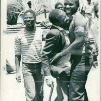 Mr. Patrick Ouma Onyango (with stick) is mobbed by a fellow student outside the courts after they were released