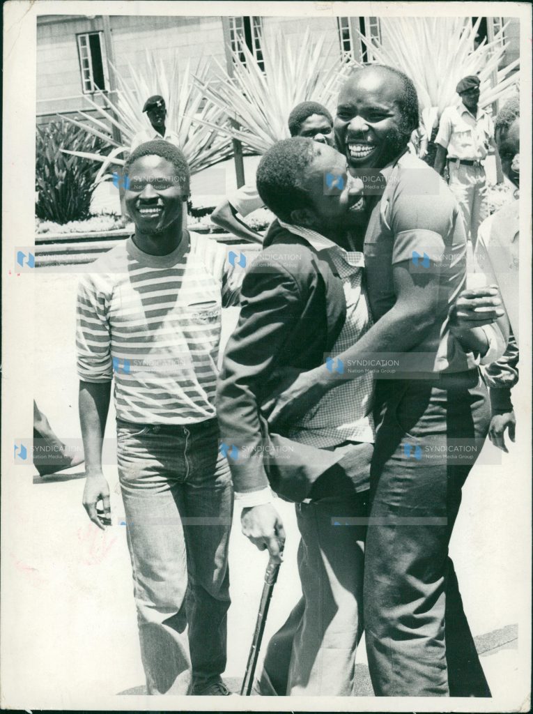Mr. Patrick Ouma Onyango (with stick) is mobbed by a fellow student outside the courts after they were released