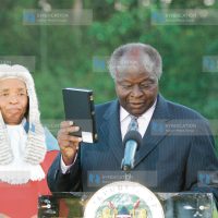 President Mwai Kibaki holds the Bible as he sworn in at State House