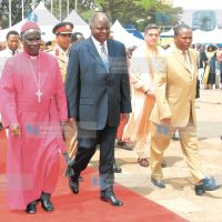 President Mwai Kibaki is escorted by Bishop Benjamin Ndzimbi and Minister Maina Kamanda