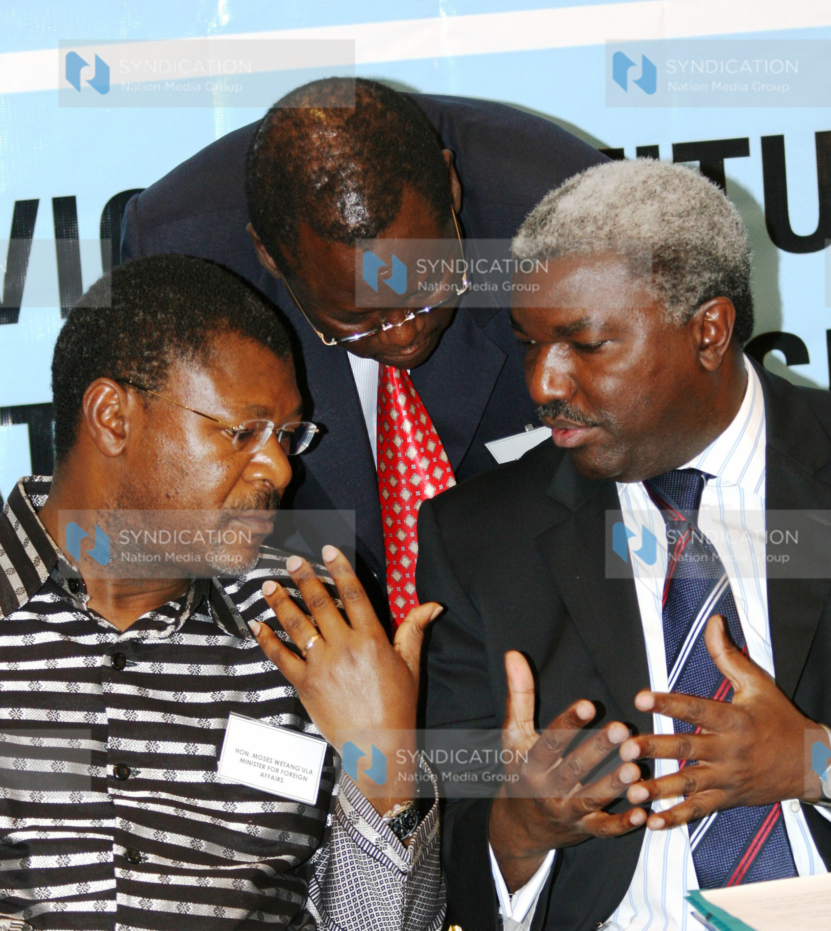Foreign Affairs Minister Moses Wetangula consults with his Permanent Secretary Thuita Mwangi and Dr. Kipyego Cheluget
