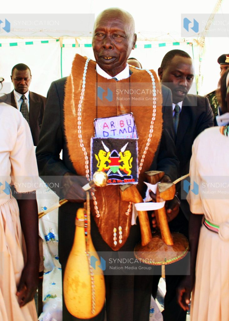 Former President Daniel Arap Moi carries gifts presented to him by Kereger Women Group