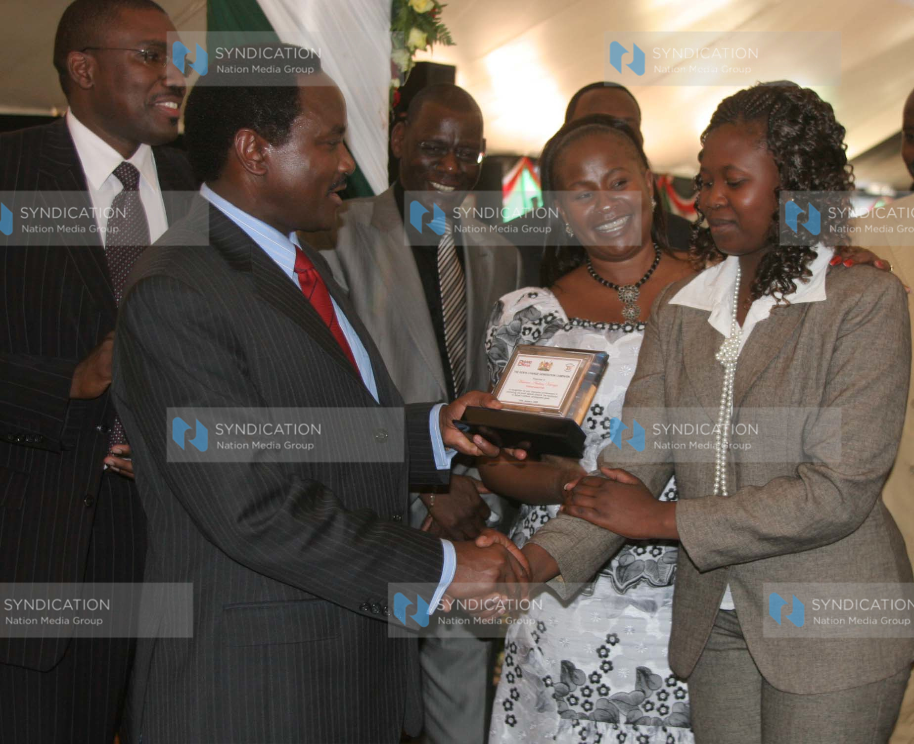 Vice president Kalonzo Musyoka presents an award to Moreen Ambasa for her role in Entrepreneurship