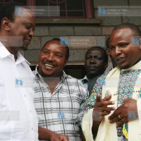Deputy Prime Minister Uhuru Kenyatta and Embakasi MP aspirant Ferdinand Waititu listen to Fr. Simon Mwangi