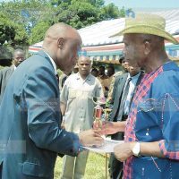 Vice President Moody Awori presents trophy to the Principal of Sigalame Secondary School Mr. Paul Muhula