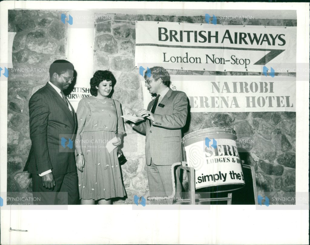 Munira Pirbahai, a secretary with E A Packaging Industries receives a return air ticket to London from Mrs. Chris Cross, British Airways' manager for Kenya Mr. John Macharia, the airline's sales manager