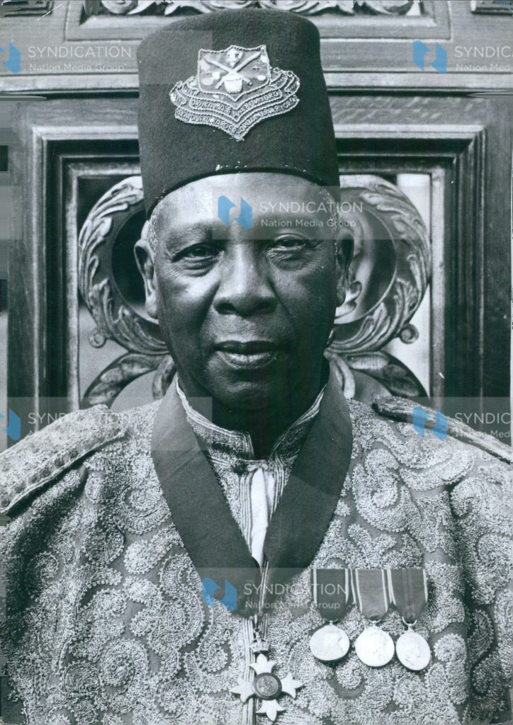The image shows Sir Tito G. Winyi IV, C.B.E., Omukama of Bunyoro Kitara