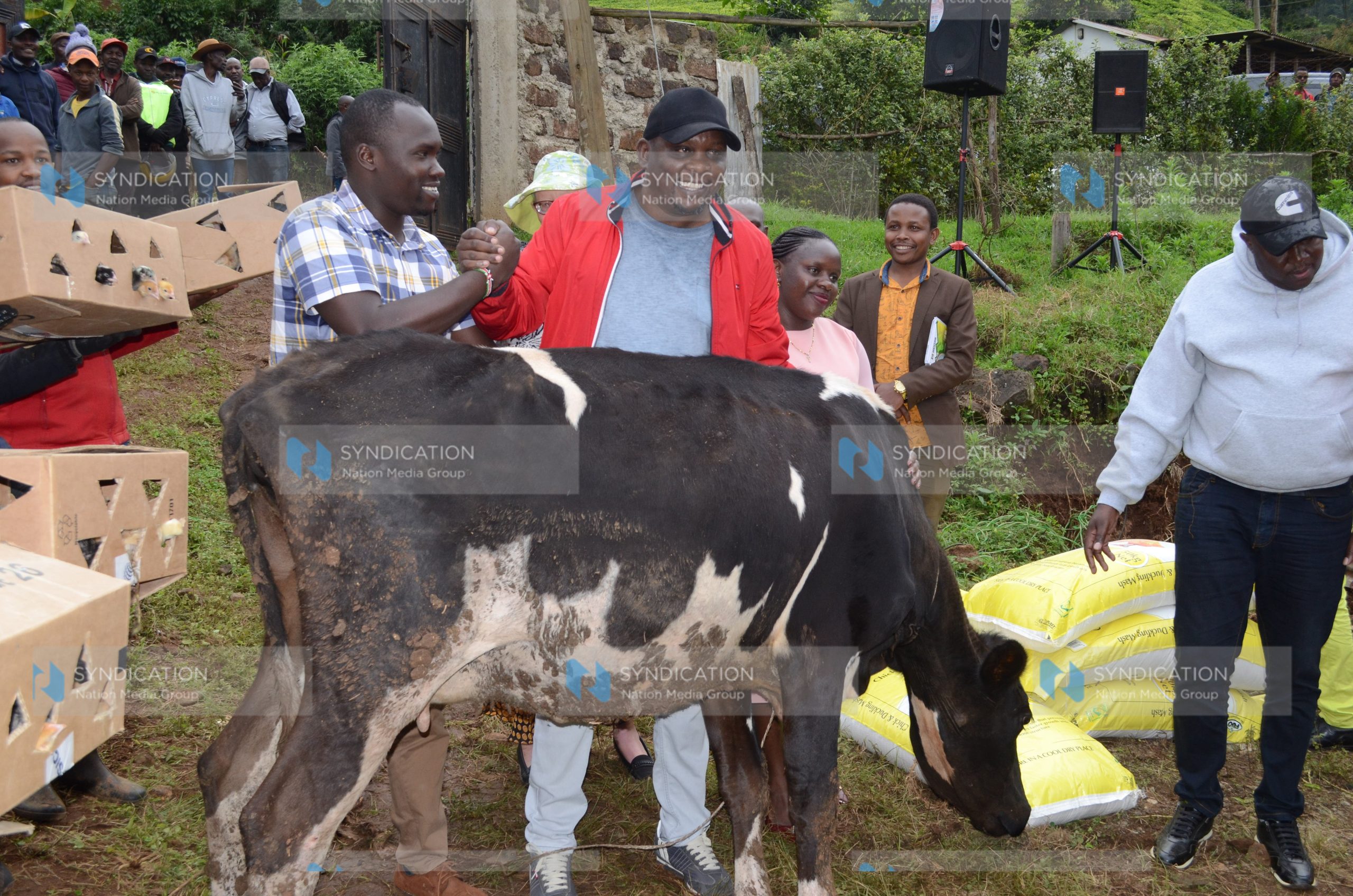 Ahadi Kenya Trust CEO Stanley Kamau presents a dairy cow to Geoffrey Gakiria
