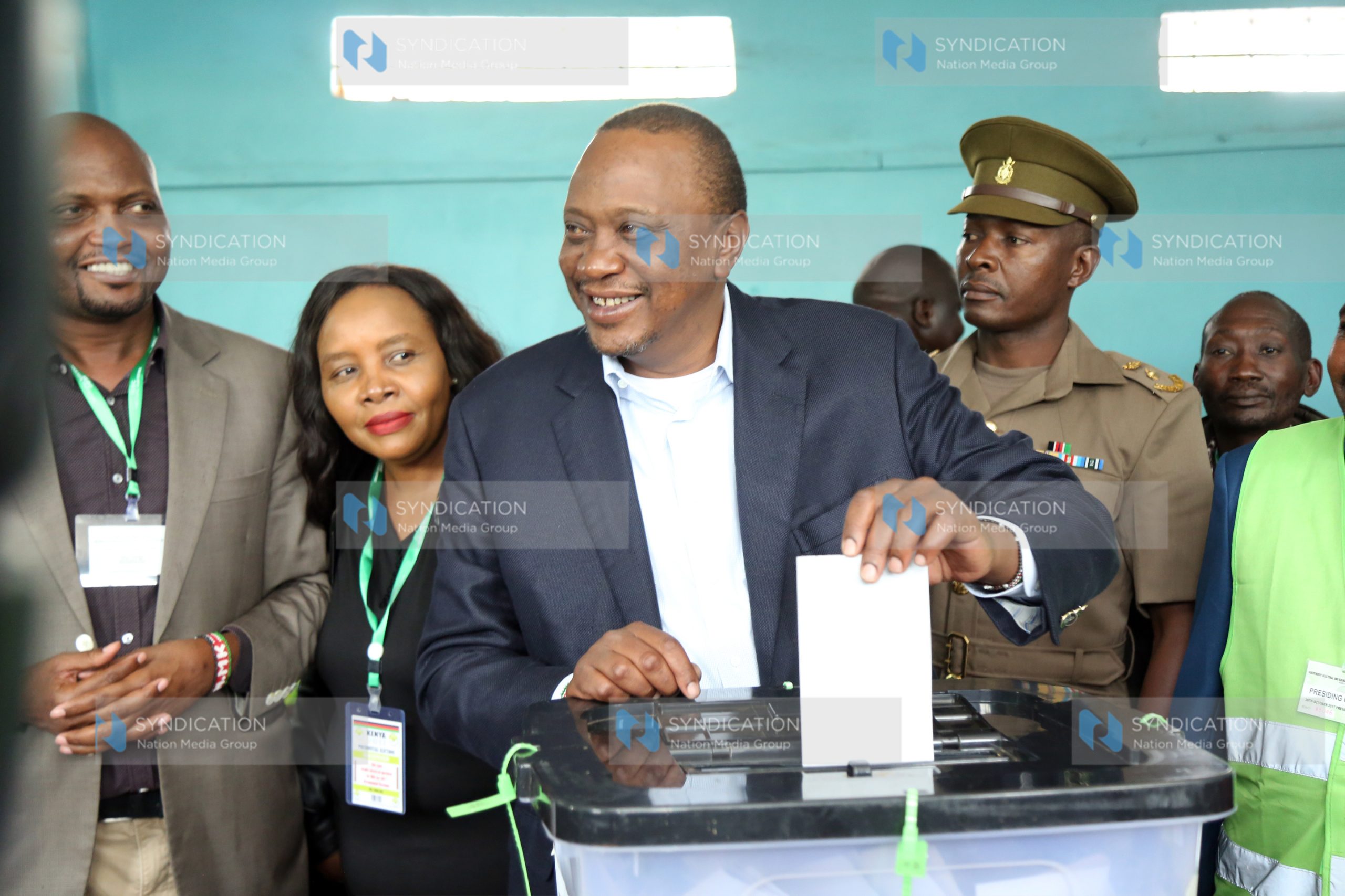 Kenya’s President Uhuru Kenyatta casts his ballot as he votes at a polling station