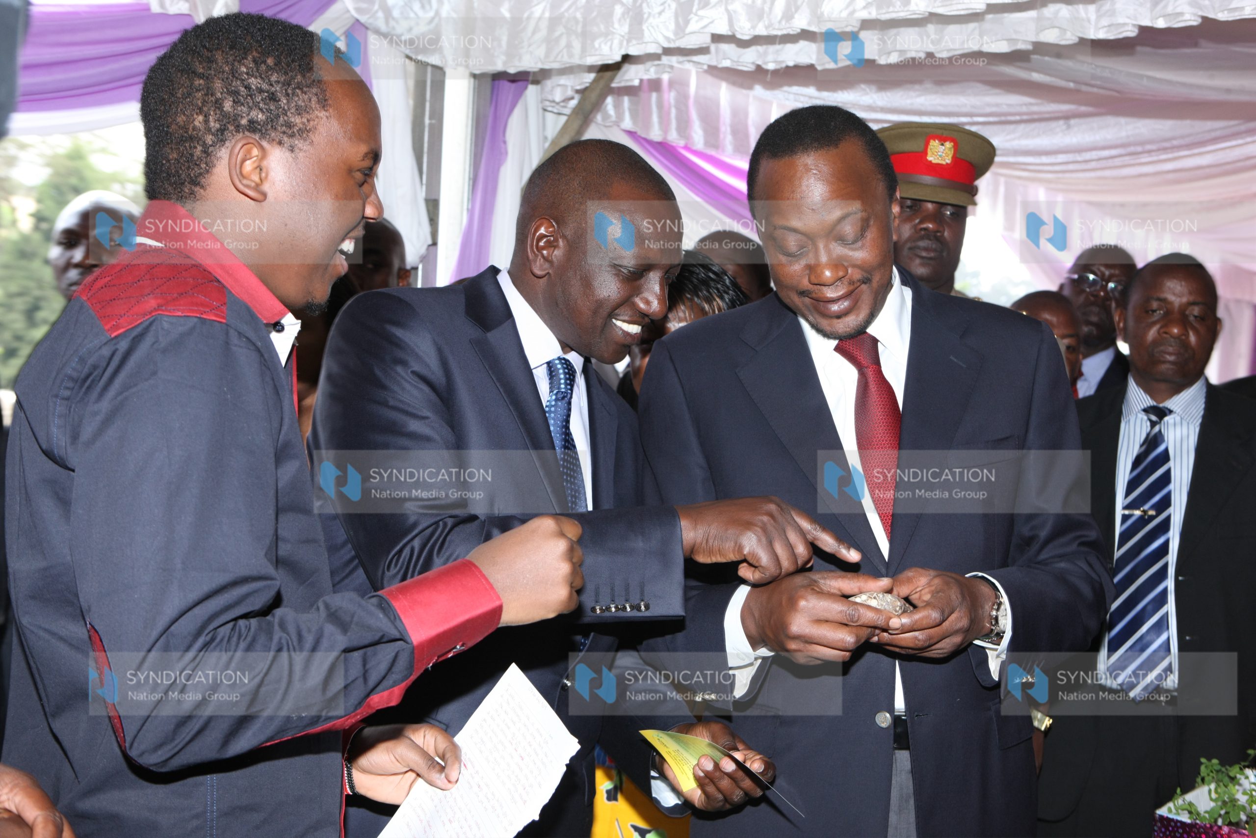 President Uhuru Kenyatta and Deputy President William Ruto are shown a shoe-making product