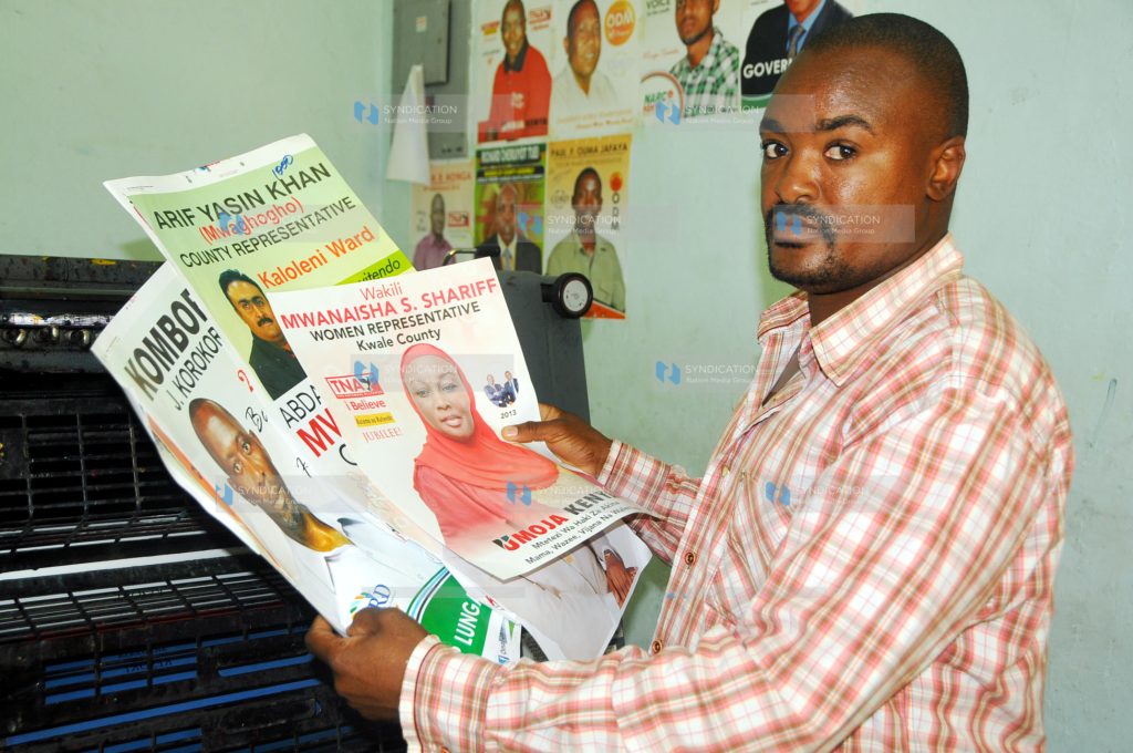 Ezra Areba of DocuCare Limited displays some of the samples of election campaign posters