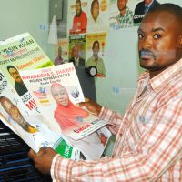 Ezra Areba of DocuCare Limited displays some of the samples of election campaign posters