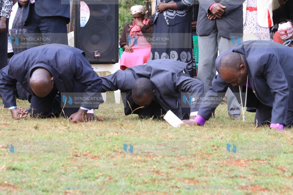 Pastors kneel during a prayer meeting for peace at Gichira Stadium