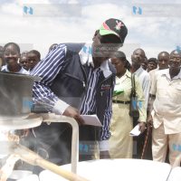 Agriculture Minister William Ruto admires a solar stove