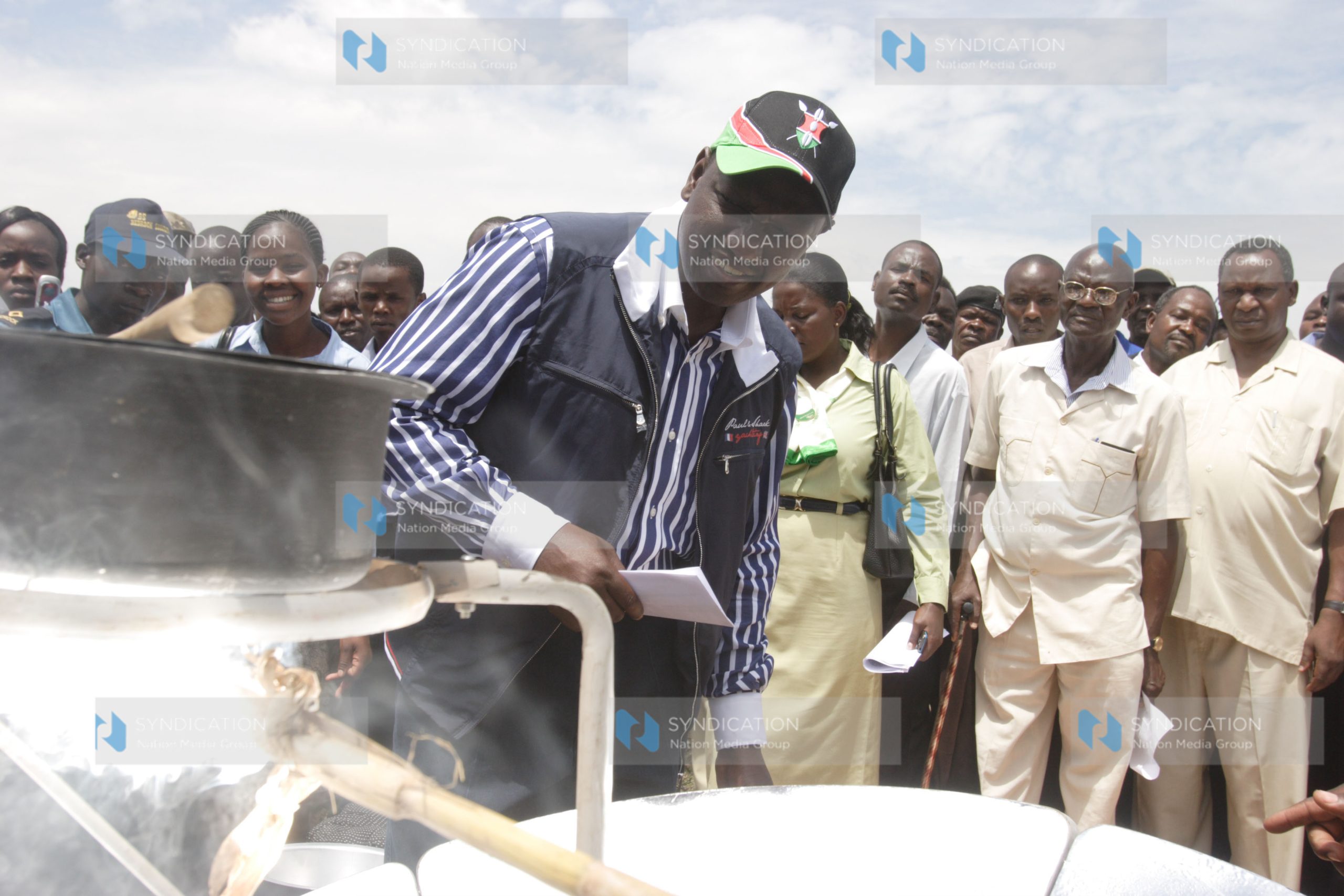 Agriculture Minister William Ruto admires a solar stove